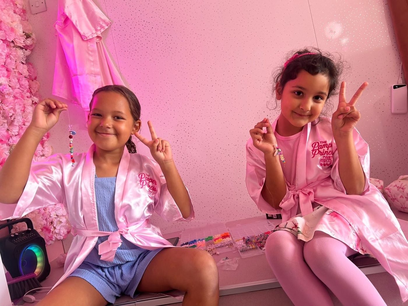 Two girls showing off their handmade bracelets