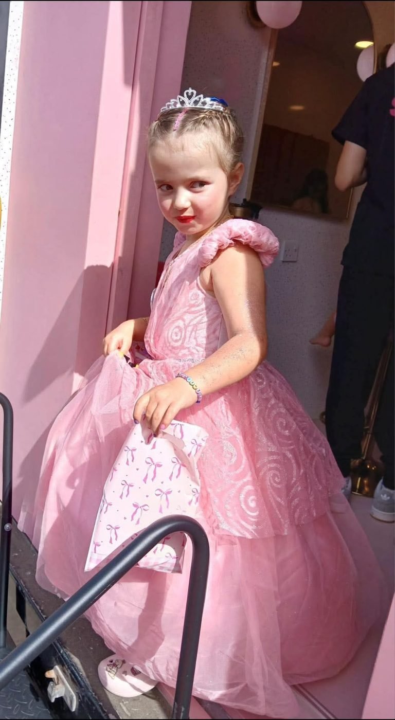 Birthday princess in a pink dress at the pamper bus door